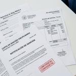 Conjunto de documentos laborales sensibles —nómina, parte de baja médica y expediente disciplinario— sobre una mesa de oficina, mostrando la información personal que debe ser destruida de forma segura
